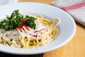 A closeup view of a plate of spaghetti in a restaurant or kitchen setting.