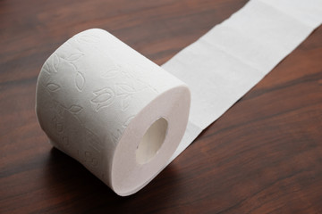 Hygiene and cleanliness. Roll of white toilet paper on a wooden background