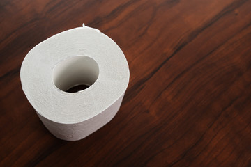 Hygiene and cleanliness. Roll of white toilet paper on wooden background with copy space