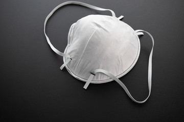 Coronavirus. Mandatory remedy. White antibacterial medical mask on a black background