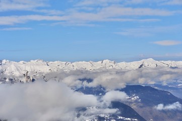 Fototapeta na wymiar Clouds over the snowy mountain with blue sky background 
