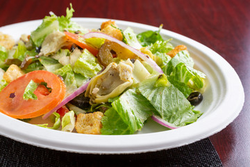A view of a greek style salad, in a restaurant or kitchen setting.