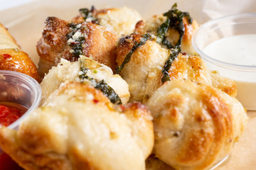 A closeup view of garlic knots, in a restaurant or kitchen setting.
