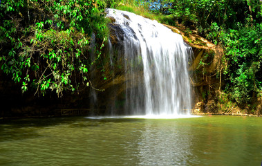 A beautiful waterfall in Vietnam in sunny warm summer day and a lot of green trees around