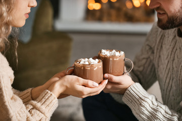 Happy young couple drinking hot cocoa at home