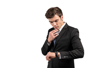 Thoughtful businessman looking at watch, isolated