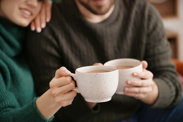 Happy young couple drinking hot cocoa at home