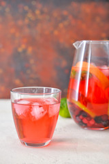 Glass and jug of tasty cold tea on table