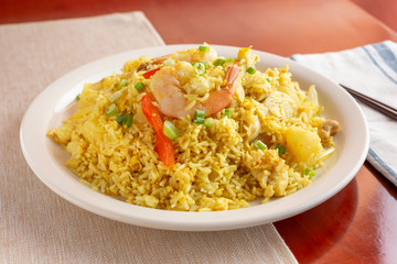 A view of a plate of fried rice in a restaurant or kitchen setting.
