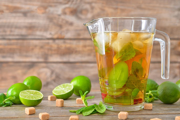 Jug of tasty cold tea on wooden table