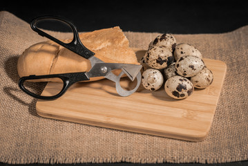 Composición con huevos de codorniz, tijeras y pan