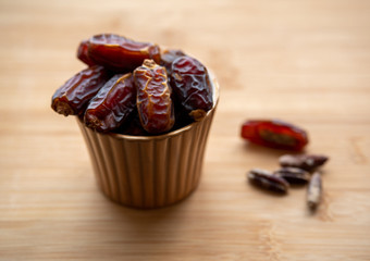 dates in a bowl on a wooden table . Top view.