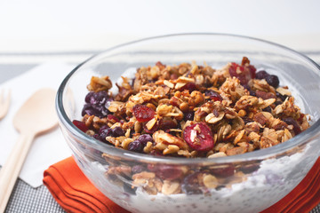A view of a chia pudding bowl with granola toppings, in a restaurant or kitchen setting.