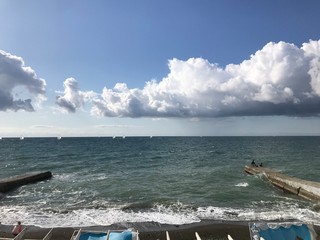 seascape, blue waves, boats in the distance.