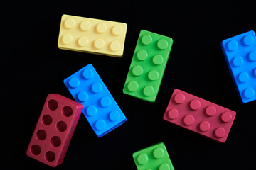 Colorful construction bricks on a black background