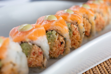 A closeup view of the middle portion of an orange dragon roll sushi plate, in a restaurant or kitchen setting. © DAVID