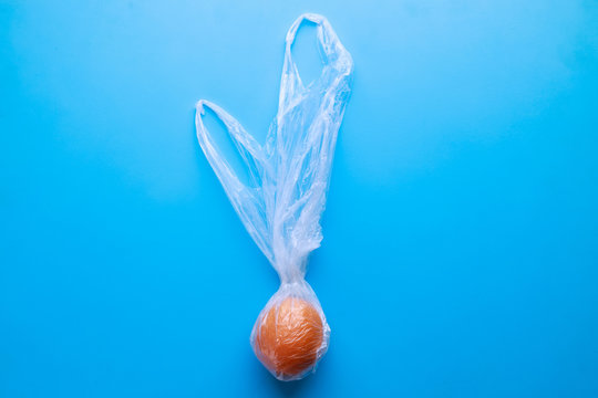 Plastic pollution, environmental and ecological concept. Fresh orange in plastic bag. Recycled waste, microplastic