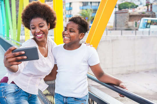 Happy Young Mother Having Fun With Her Child In Summer Day - Son Taking Selfie With His Mum Outdoor - Family Lifestyle, Motherhood, Love And Technology Concept - Focus On Faces