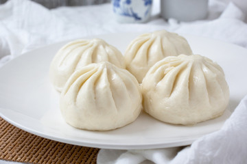 Fototapeta na wymiar A view of a plate of Chinese buns called baozi, in a restaurant or kitchen setting.