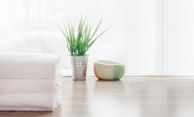 Fototapeta na wymiar Folded clean white towels and houseplant on wooden table.