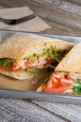 A view of a Ciabatta tomato and cheese sandwich in a restaurant or kitchen setting.