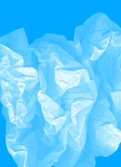 Airy vertical image. Blue large light elegant cloud of crumpled paper on a cyan background. Crushed, creased and wrinkled paper. The concept of lightness, transparency. A modern perfect image for text