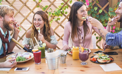 Young people eating brunch and drinking smoothies bowl with in eco bar restaurant - Healthy lifestyle, food trends concept - Focus on right girl face