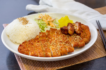 A view of a plate of tonkatsu, in a restaurant or kitchen setting.