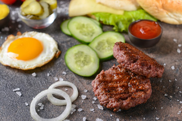Ingredients for tasty burger on dark background
