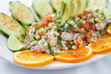 A closeup view of a plate of shrimp ceviche, in a restaurant or kitchen setting.