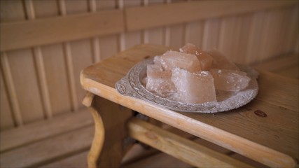 Salt in the sauna. Salt therapy. Salt in a plate in the interior of the sauna.