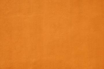 orange wall covered with plaster with small cracks