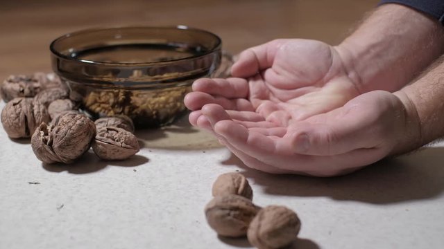 Cracking a walnuts at home.
Hammer to break nuts. Collects a nuts in glass bowl