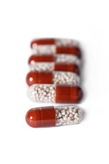 a handful of two-tone tablets on a white background, capsules with granules inside, vitamins, care health 