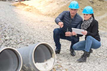Construction manager and architect read their notes on a tablet  on a buildding site