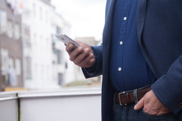 businessman using mobile or cell phone on the office balcony