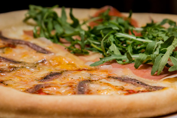 Pizza artigianale fatta in casa al forno con rucola acciughe salsiccia mozzarella pomodoro