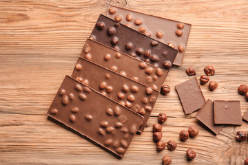 Sweet chocolate with nuts on wooden table