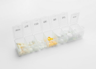 Container with pills on white background
