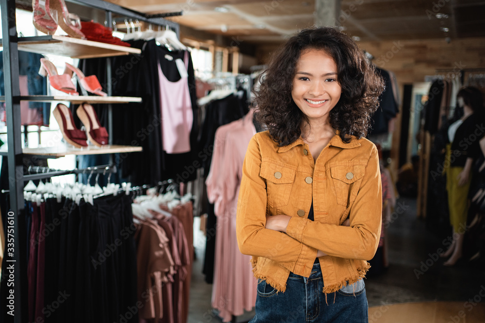 Wall mural beautiful young asian fashion shop owner at her boutique standing proudly and smile to camera