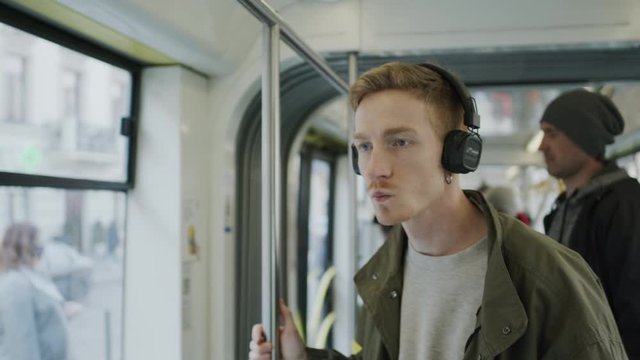 Young Guy With Headphones Rides In Bus.