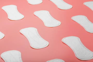 Sanitary pad on a pink background in the form of a diagonal pattern. Textured background over the entire screen.