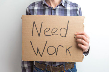 Need work, the inscription in the hands of the employee. The concept of unemployment, crisis. Need a job.