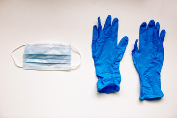 Virus protection surgical face mask and dark blue  gloves for  coronavirus placed on white background with copy space