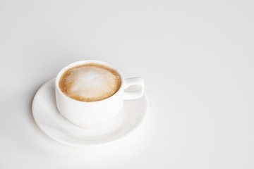 Cappuccino cup with frothy foam on white background. Copy space