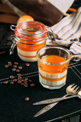 Panacotta dessert with peach in a jar on a dark background with decorative elements, side view, vertical