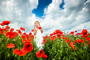 Cute child girl in poppy field