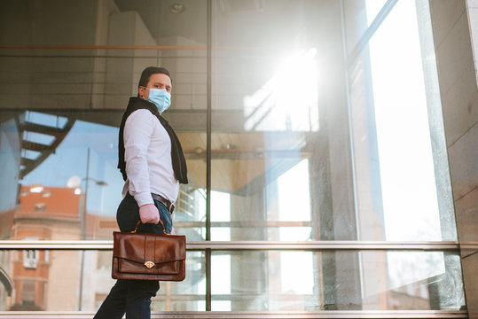 
Young Businessman Walking With Gloves And Face Mask In Front Of Company. COVID - 19 Virus Protection