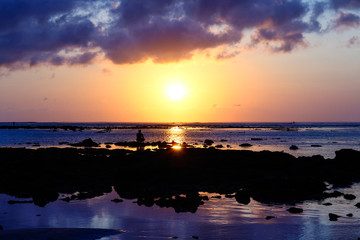 Obraz premium Silouette of a man on the beach at the sunset