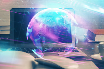 Obraz premium Computer on desktop in office with technology theme hologram. Multi exposure. Tech concept.